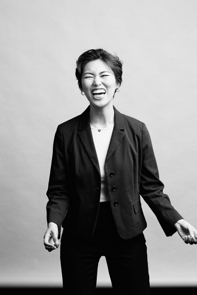 Black and White studio headshot by Photoform* of woman laughing.